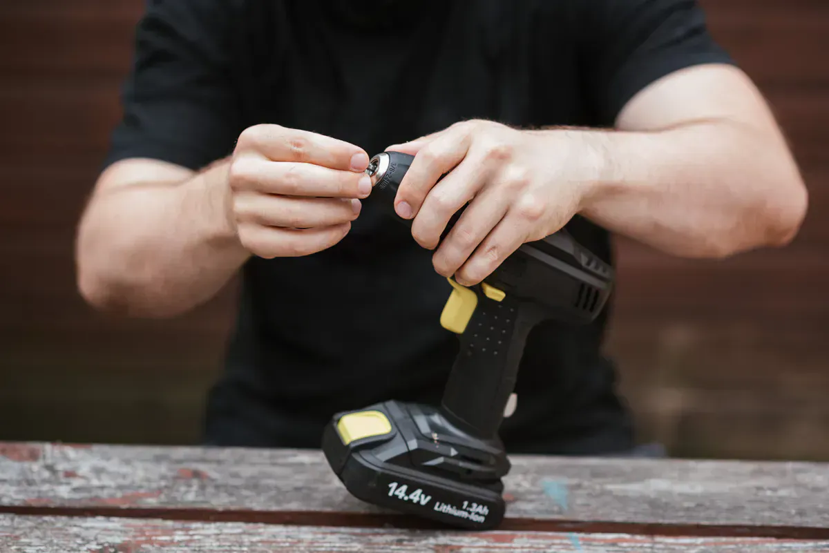Fitting a bit into a cordless drill before running a vent rod kit