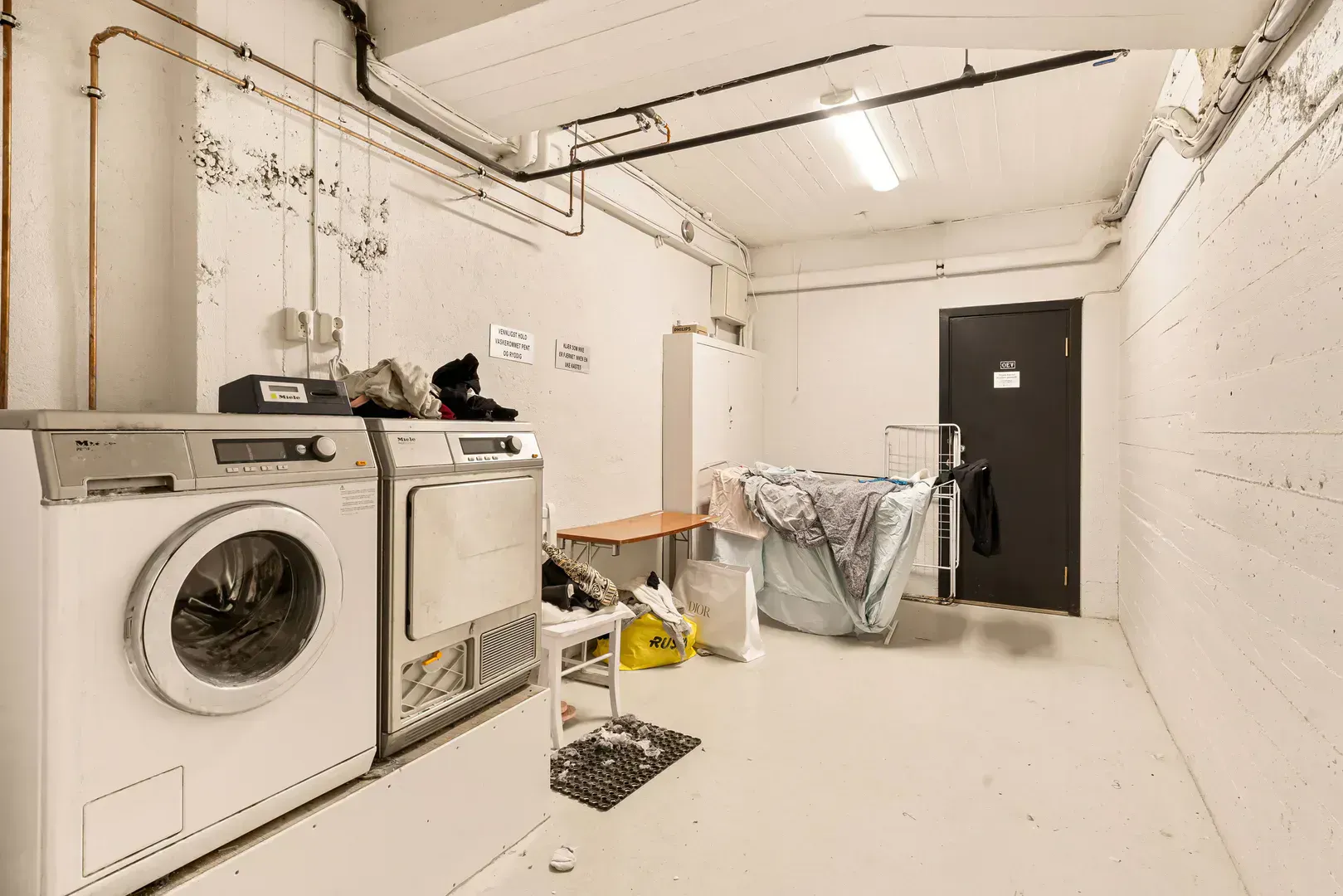 Laundry room with exposed water supply piping
