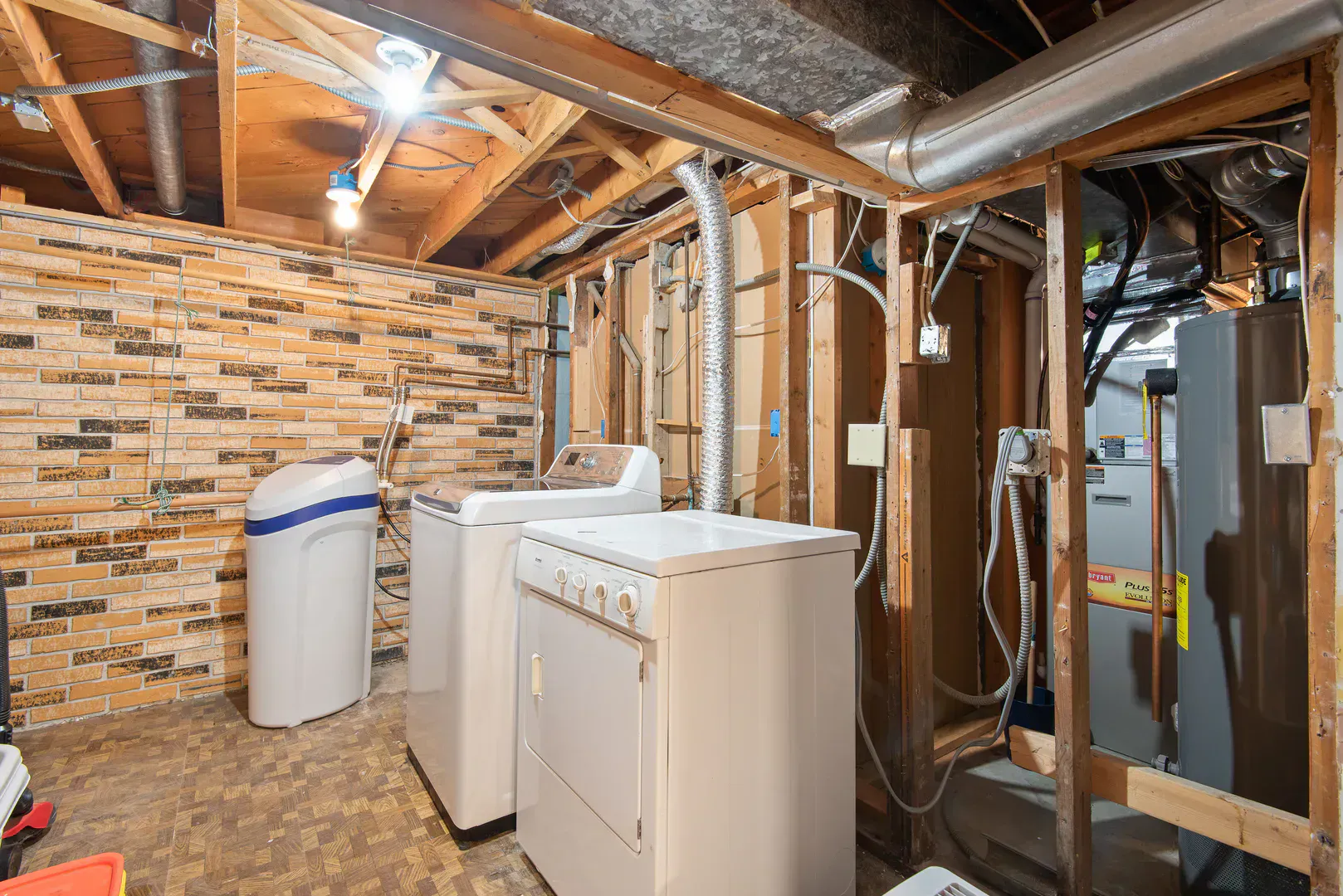 Basement laundry room with exposed brick